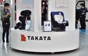 (FILES) - A file picture taken on November 11, 2014 shows visitors look at displays of Japanese auto parts maker Takata Corp at a car showroom in Tokyo on November 11, 2014. Embattled Japanese auto parts maker Takata has published an open letter in major US and German media, vowing to step up its safety record after an airbag crisis hammered the company's reputation. AFP PHOTO / KAZUHIRO NOGI / FILES
